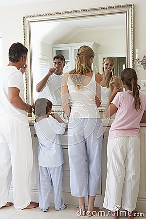 Family Brushing Teeth In Bathroom Mirror Stock Photo