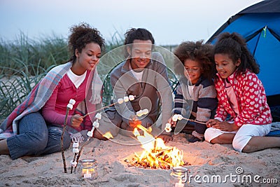 Family Camping On Beach And Toasting Marshmallows Stock Photo