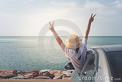 Family car trip at the sea, Portrait woman cheerful raising her hands up and feeling happiness. Stock Photo