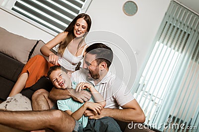 Family in casual home look lies on a cozy carpet in the living room Stock Photo