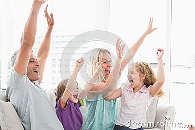 Family celebrating success while watching TV Stock Photo