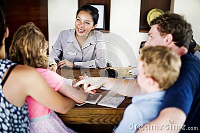 Family checking in at resort reservation counter Stock Photo