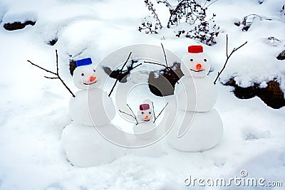 Family of cheerful snowmen rejoice at the arrival of winter and the first snow Stock Photo