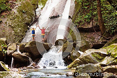 Family with child at waterfall. Travel with kids Stock Photo