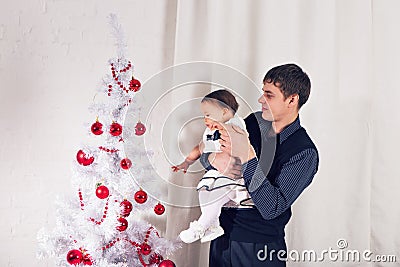 Family, children, christmas, x-mas, love concept - happy father with adorable baby daughter near christmas tree Stock Photo