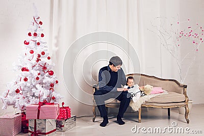 Family, children, christmas, x-mas, love concept - happy father with adorable baby daughter near christmas tree Stock Photo