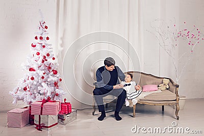 Family, children, christmas, x-mas, love concept - happy father with adorable baby daughter near christmas tree Stock Photo