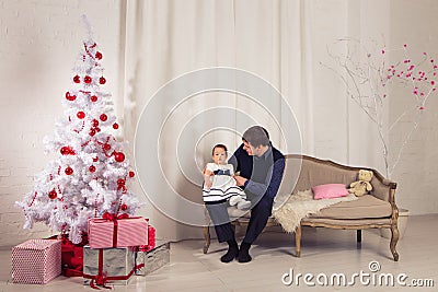 Family, children, christmas, x-mas, love concept - happy father with adorable baby daughter near christmas tree Stock Photo