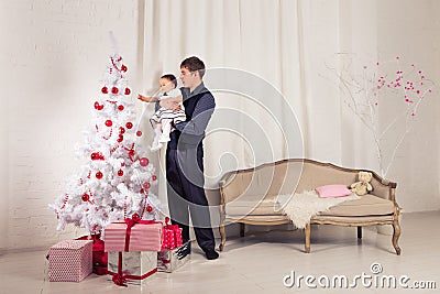 Family, children, christmas, x-mas, love concept - happy father with adorable baby daughter near christmas tree Stock Photo