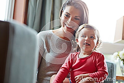 Family, children or love with a mother and girl together in the living room of their home, sitting on a sofa. Mama, baby Stock Photo