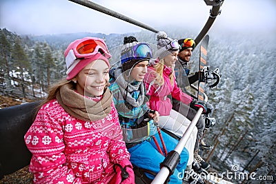 Family in ski lift going to ski terrain Stock Photo