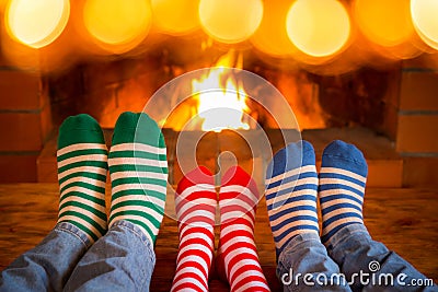 Family in Christmas socks near fireplace Stock Photo