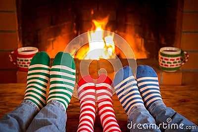 Family in Christmas socks near fireplace Stock Photo