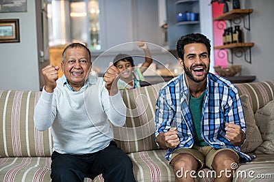 Family clenching fist while watching soccer match Stock Photo
