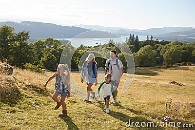 Family Climbing Hill On Hike Through Countryside In Lake District UK Together Stock Photo