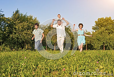 Family Concept and Ideas. Happy Family of Four Running Together Stock Photo