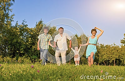 Family Concept and Ideas. Happy Family of Four Running Together Stock Photo