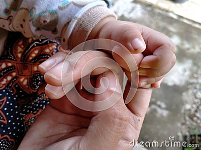 Family concept protection and happiness, the baby`s hand is held by the mother Stock Photo