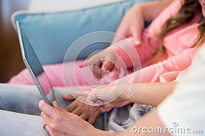 Family on the couch together using tablet pc Stock Photo