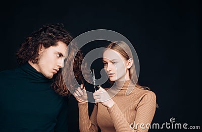 Family crisis. Girl scheming an evil plan of cutting off a curly hair in a man. A smart wily woman has wonderful schemes Stock Photo