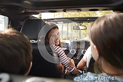 Family Driving In Open Top Car On Countryside Road Trip Stock Photo