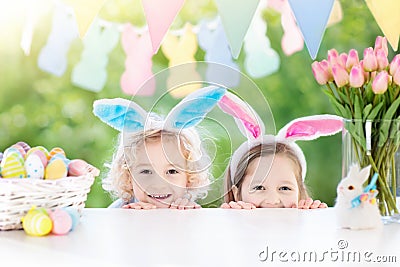 Kids with bunny ears and eggs on Easter egg hunt. Stock Photo