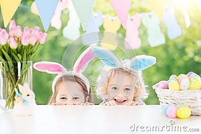 Kids with bunny ears and eggs on Easter egg hunt. Stock Photo