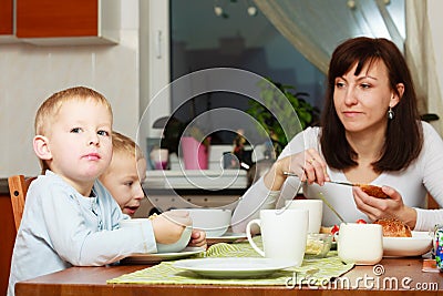 Family eating corn flakes and bread breakfast meal at the table Stock Photo