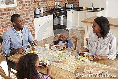 Family Eating Meal In Open Plan Kitchen Together Stock Photo