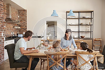 Family Eating Meal In Open Plan Kitchen Together Stock Photo