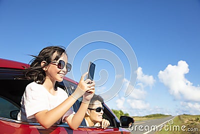 Family enjoy road trip taking picture by smart phone Stock Photo
