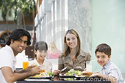 Family enjoying lunch at cafe Stock Photo