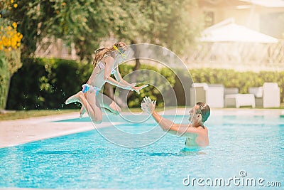 Family of mom and little daughter enjoying summer vacation in luxury swimming pool Stock Photo