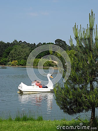 Family enjoying swan pedal boat at Woburn Safari Park, UK Editorial Stock Photo