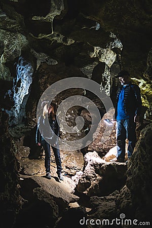 Family exploring huge cave. Adventure travellers dressed cowboy hat and backpack, group of people. vertical photo vacation, Stock Photo