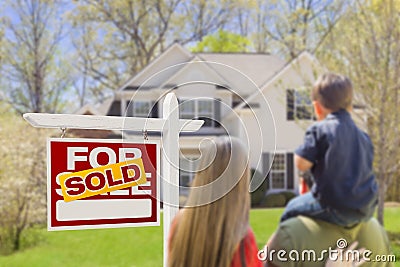 Family Facing Sold For Sale Real Estate Sign and House Stock Photo