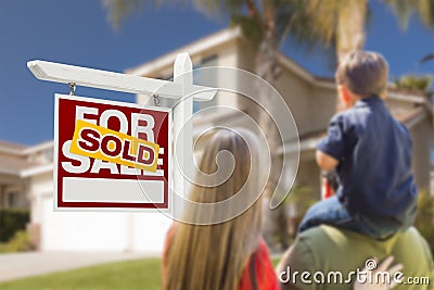 Family Facing Sold For Sale Real Estate Sign and House Stock Photo