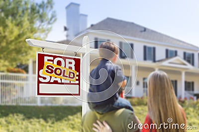 Family Facing Sold For Sale Real Estate Sign and House Stock Photo