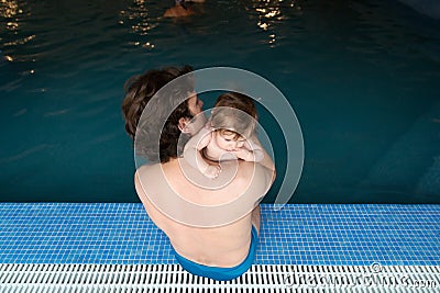 Family of father and his little daughter sitting at edge of swimming pool. Young father and his little cute newborn baby Stock Photo