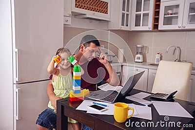 Family - father working with computer while looking after his da Stock Photo