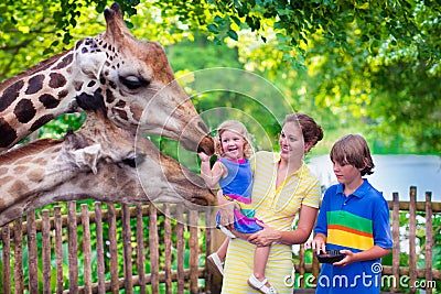 Family feeding giraffe in a zoo Stock Photo