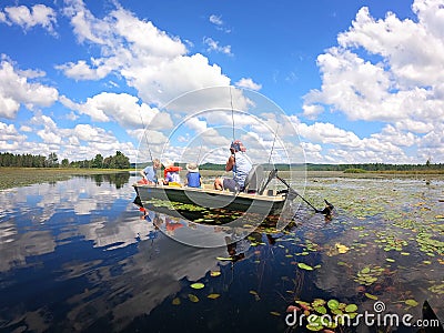 Family Fishing and Relaxing on Boats on a Pristine Secluded Lake on Summer Day Stock Photo