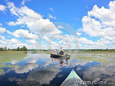 Family Fishing and Relaxing on Boats on a Pristine Secluded Lake on Summer Day Stock Photo