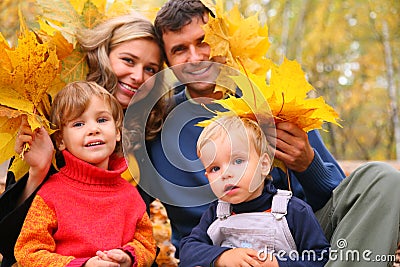 Family of four with yellow maple leaves Stock Photo