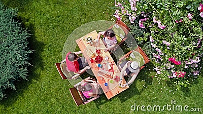 Family and friends eating together outdoors on summer garden party. Aerial view of table with food and drinks from above Stock Photo