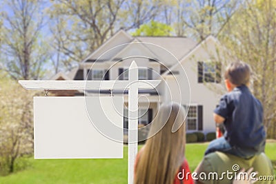 Family in Front of Blank Real Estate Sign and House Stock Photo