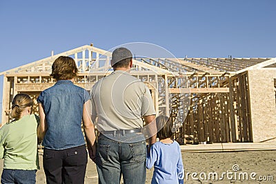 Family In Front Of Incomplete House Stock Photo