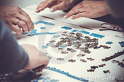 Family hands solving jigsaw Stock Photo