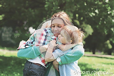 Family happiness! Happy mother tenderly embracing his two sons Stock Photo