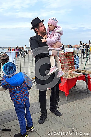 A family of Hasidic Jews, a man with children, walking at the festival. Religious Orthodox Jew with a girl. Dnipro city, Editorial Stock Photo
